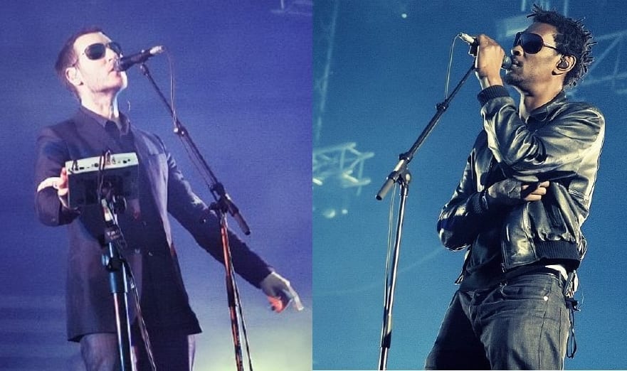 A two-panel photo of Robert del Naja in a dark suit and sunglasses singing into a microphone, beside Grant Marshall in a leather jacket and sunglasses singing into a microphone, both under blue stage light.